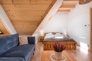 1 dormitorio con 1 cama y 1 sofá azul en Domek Asina Chata Zawoja, en Zawoja