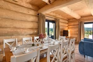 a dining room with a white table and chairs at Domek Asina Chata Zawoja in Zawoja
