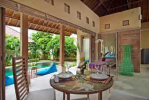a living room with a table and a pool at Villa Domus Dua in Seminyak