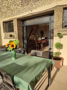 a green table with a vase of sunflowers on a patio at Le 1881 Ampuis in Ampuis