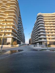 two tall buildings next to a street in front of a building at Studio Casa del Mar - Mathi in Mamaia