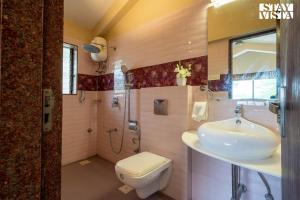 a bathroom with a sink and a toilet at River Song by VEO - Part of StayVista in Lonavala +21 photos