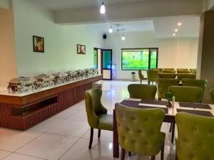 a restaurant with green chairs and tables and a counter at Pineland Resorts & Chalets Kasauli in Kasauli