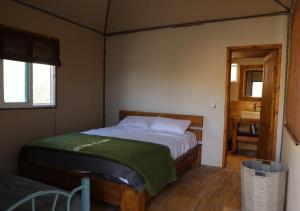 ein kleines Schlafzimmer mit einem Bett und einem Badezimmer in der Unterkunft Rum Planet Camp in Wadi Rum