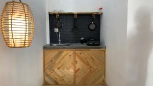 cocina con armario de madera y fregadero en Kenan Cottage, en Canggu