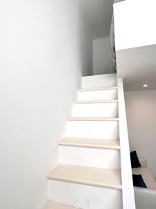 a staircase in a house with white walls at Bright Bookworm's Haven in Sliema