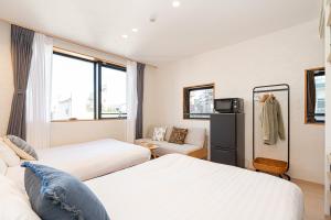 Habitación de hotel con 2 camas y sofá en ZAITO Tokyo Narihira Hotel　押上駅から徒歩八分ホテル, en Tokio