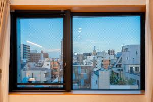 a window with a view of a city at ZAITO Tokyo Narihira Hotel　押上駅から徒歩八分ホテル in Tokyo