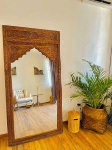 a mirror in a living room with a couch and a table at La Plage Classique Beachfront Nusa Penida in Nusa Penida