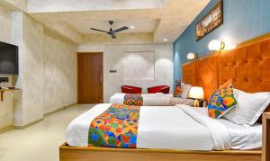 a bedroom with two beds and a flat screen tv at FabHotel Siddharth Corporate in Gandhinagar