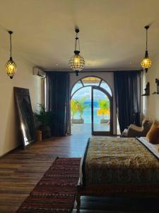 a bedroom with a bed and an arched doorway at La Plage Classique Beachfront Nusa Penida in Nusa Penida