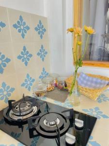 a kitchen with a stove top with a vase of flowers at La Plage Classique Beachfront Nusa Penida in Nusa Penida