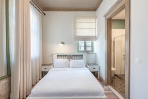 een slaapkamer met een groot wit bed in een kamer bij Elia Hotel Cunda by Ortunc in Ayvalık