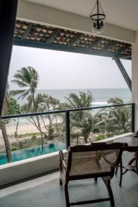 um quarto com uma grande janela com vista para a praia em Naomi Beach Resort - Adults only em Weligama