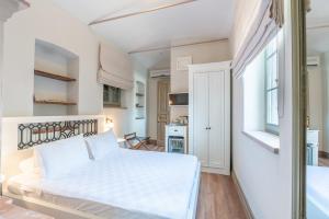 a bedroom with a white bed and a kitchen at Elia Hotel Cunda by Ortunc in Ayvalık