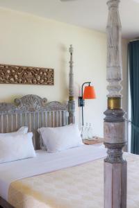 - une chambre avec un grand lit et des draps blancs dans l'établissement Naomi Beach Resort - Adults only, à Weligama