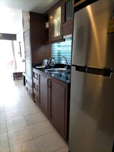 a kitchen with a refrigerator and a sink at Sea Sand Sun Resort in Ban Phe