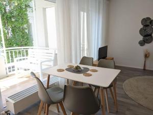 a living room with a white table and chairs at Zentrale Stadtperle, 3 Zimmer, Loggia u. Parkplatz in Karlsruhe