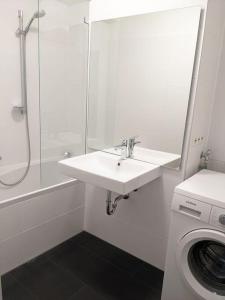 a white bathroom with a sink and a washing machine at Zentrale Stadtperle, 3 Zimmer, Loggia u. Parkplatz in Karlsruhe