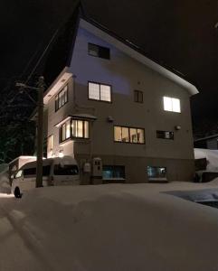a building with a lot of snow in front of it at Elan Lodge Akakura in Nagano