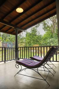 two lounge chairs sitting on a porch with a railing at The villaRo in Hikkaduwa