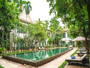 einem Pool vor einem Gebäude mit Bäumen in der Unterkunft Tanei Angkor Resort and Spa in Siem Reap