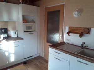a kitchen with white cabinets and a sink and a microwave at Bianca,s Ferienwohnung in Bad Mitterndorf