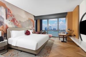 a bedroom with a large bed and a tv at M Social Hotel Suzhou in Suzhou