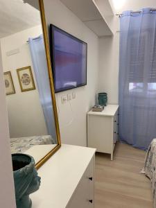 Habitación con espejo y TV en la pared. en Amor blue -Relax and Beach, en Marina di Carrara