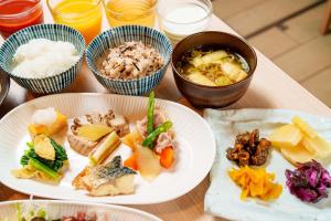 東京的住宿－Henn na Hotel Tokyo Hamamatsucho，餐桌,盘子上放着食物和碗