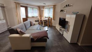 a living room with a couch and a television at Ferienwohnung Lang in Breitenbrunn