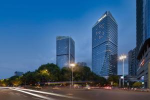 dos rascacielos altos en una ciudad por la noche en M Social Hotel Suzhou en Suzhou