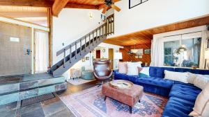 a living room with a blue couch and a staircase at Courchevel #5 condo in Mammoth Lakes