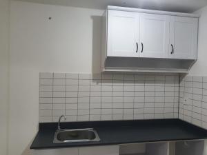 a kitchen with white cabinets and a sink at sayana apartment tower cha in Hutanhawit