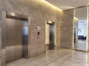 un vestíbulo de ascensor con 2 ascensores en un edificio en sayana apartment tower cha, en Hutanhawit