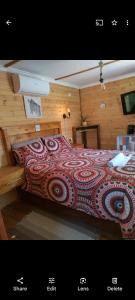 a bedroom with a bed with a red comforter at The CabinGuesthouse in Gaborone