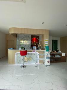 a kitchen with a red chair in a room at Love you Hotel in Phitsanulok