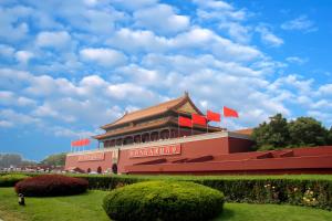 un edificio con bandiere rosse sopra di Happy Dragon Hotel - close to Forbidden City&Wangfujing Street&free coffee &English speaking,Newly renovated with tour service a Pechino