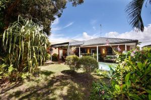 a house with a swimming pool in the yard at Absolute Beach Front Home -Dogs, Surf, Relax, Bush in Kawana Waters