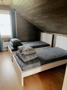 twee bedden in een kamer met een houten plafond bij HYGGE Sauna&Fishing House 
