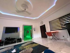 sala de estar con TV y puerta verde en OLIVER COTTAGE GUESTHOUSE, en Yamoransa
