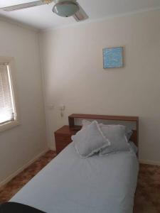 a bedroom with a bed with two pillows on it at The House with the Purple Gate in Broken Hill