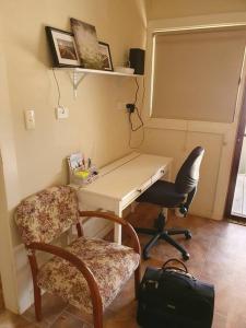 a desk and two chairs in a room at The House with the Purple Gate in Broken Hill