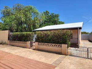 a bus stop with a building with a roof at The House with the Purple Gate in Broken Hill