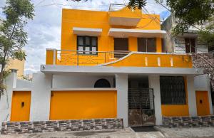 ein gelbes Haus mit Balkon darüber in der Unterkunft MPS Saai Residency in Tiruvannāmalai