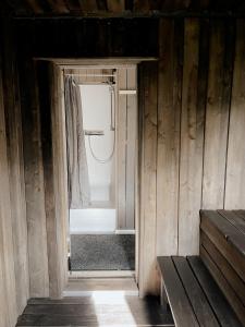 an open door to a bathroom in a wooden cabin at HYGGE Sauna&Fishing House in Jagėlonys Kalniniai +46 photos