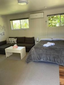 een slaapkamer met een bed en een bank bij Canberra Hospital Locum Welcome in Harman