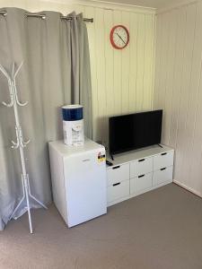 a room with a small refrigerator and a tv at Canberra Hospital Locum Welcome in Harman