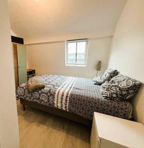 een kleine slaapkamer met een bed en een raam bij Villa Beauregard in Mers-les-Bains