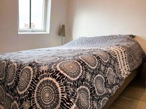 a bed with a brown and white comforter on it at Villa Beauregard in Mers-les-Bains